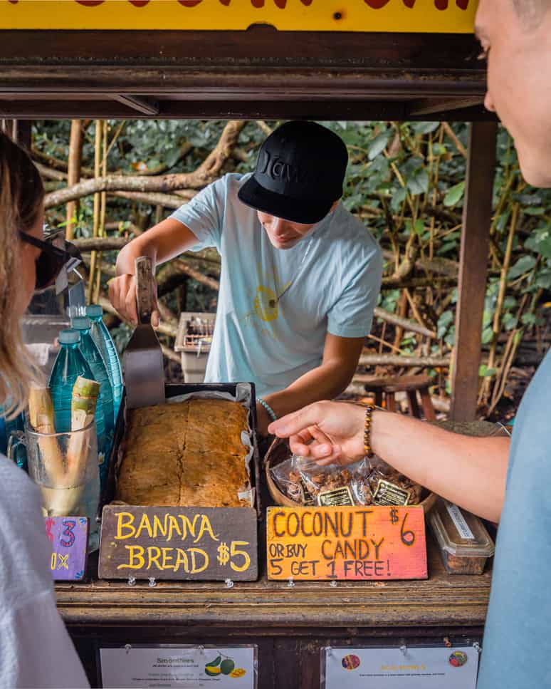 Person pointing at banana bread at a roadside stand