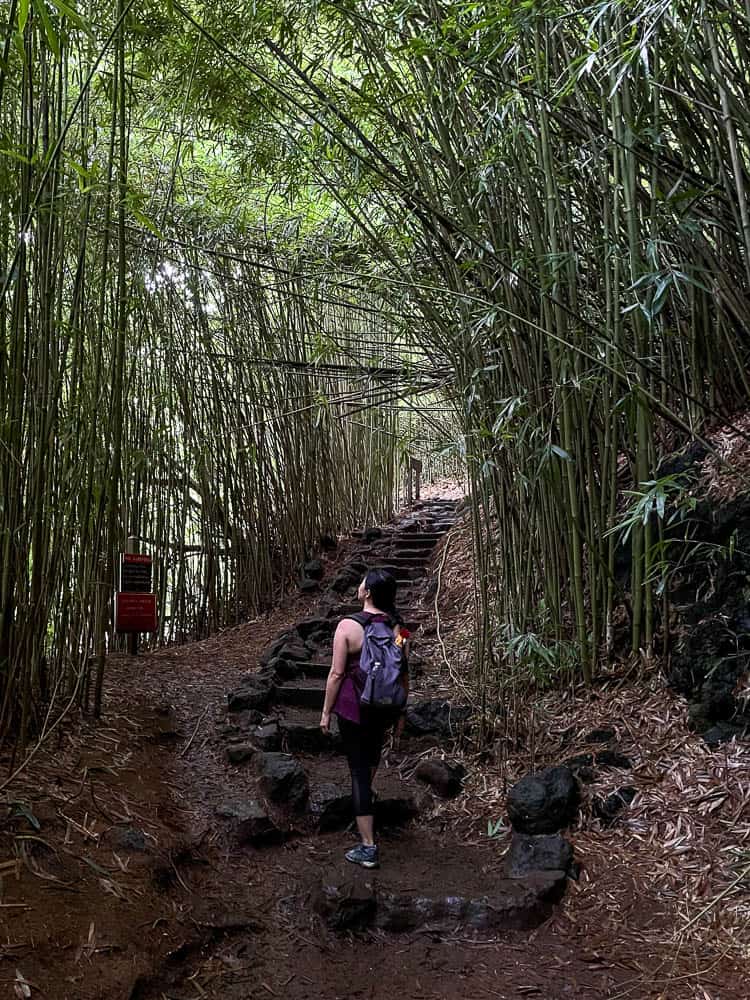 A woman walks up the stone stairway at the Pipiwai Trail bamboo forest on Maui, Hawaii.
