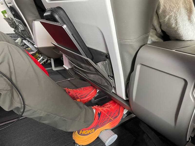 Back of an airline seat pocket with a laptop and case wedged inside.
