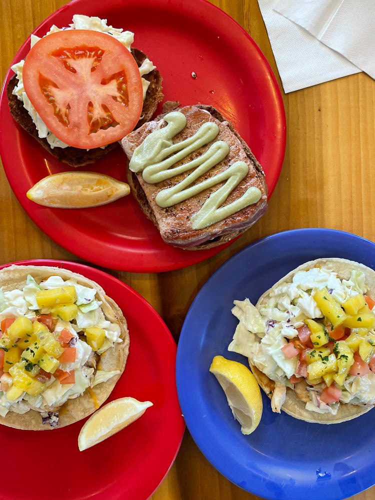 Overhead view of three dishes from Coconuts Cafe in Kihei: two fish tacos and a fish sandwich.