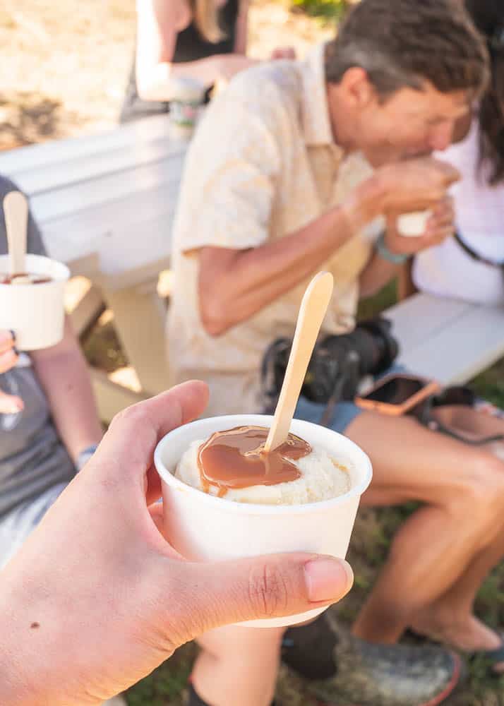 A hand holds a sample of Haleakala Creamery's goatlato with caramel sauce