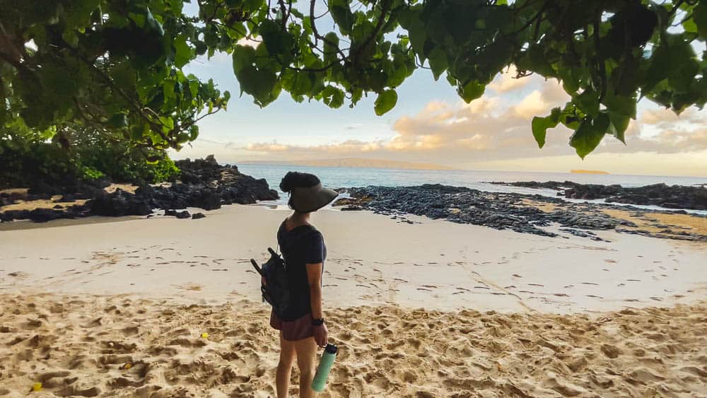 A woman stands on the beach at Makena Cove on Maui Hawaii