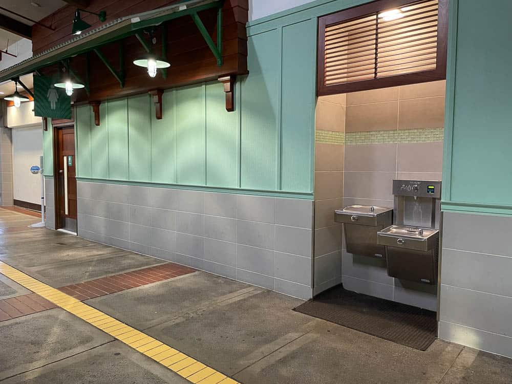 View of the women's bathroom entrance and nearby drinking fountain/bottle refill station at Kahului Airport on Maui, Hawaii