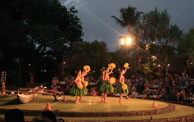 Dancers wearing traditional Polynesian dance attire perform onstage at the Old Lahaina Luau in Maui, Hawaii.