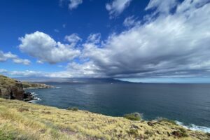 Vista lookout from a West Maui bluff overlooking the ocean with thick white clouds in the sky